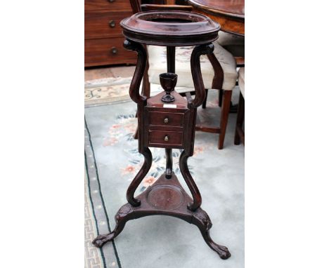 A GEORGE III MAHOGANY WASH BASIN STAND with ring top, scroll supports, the triform base with two small drawers standing on cl