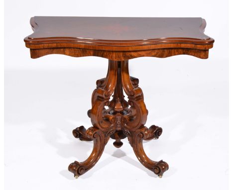 A VICTORIAN WALNUT SERPENTINE FOLD OVER TEA TABLE with central carved column surrounded by scroll supports and on four scroll