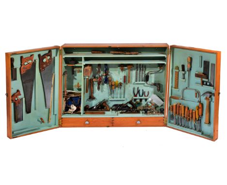 A CARPENTERS TOOL BOX for wall mounting, the two doors opening to reveal a variety of carpentry tools within, saws, planes, c