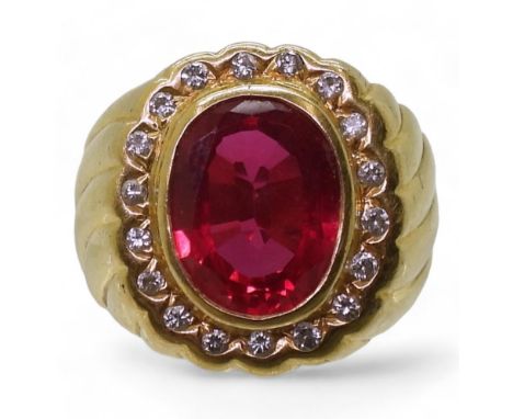 A yellow metal ring, stamped 90%, set with a red gem, and diamonds with an estimated approx diamond total of 0.18cts, finger 