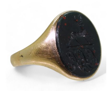 A yellow metal signet ring set with a large bloodstone intaglio carved with a stag and a monogram, stone approx 16.5mm x 14mm