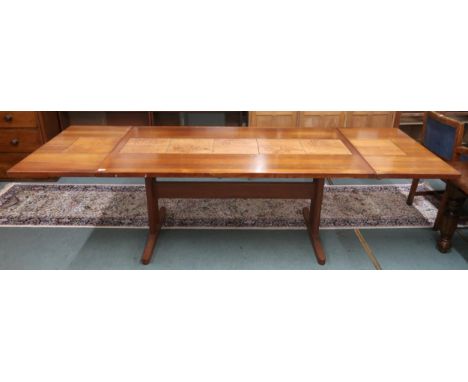 A mid 20th century Scandinavian Skovby teak tile topped extending dining table with drop ends on refectory base, 72cm high x 