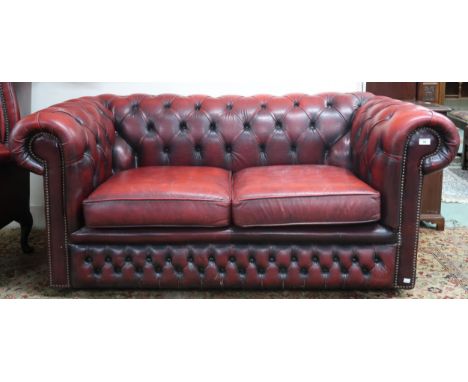 A 20th century oxblood leather upholstered two seater Chesterfield style club sofa, 70cm high x 165cm wide x 88cm deep Condit