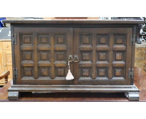 A contemporary stained teak baronial style two door side cabinet on sledge feet, 60cm high x 102cm wide x 41cm deep Condition