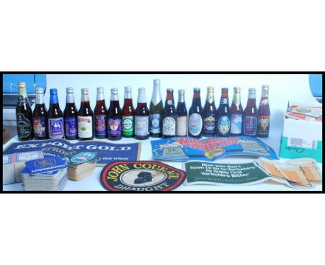 A collection of vintage 20th century breweriana beer mats and commemorative beer bottles along with bar tray and bar mats. Br