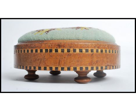 A 19th century Victorian walnut and parquetry footstool, on black surround, ceramic feet