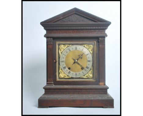 A 19th century Victorian oak cased bracket clock raised on a stepped pedestal base with classical columns to front. The gilt 
