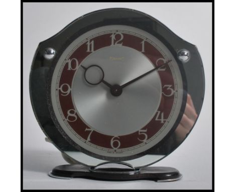 A vintage retro 20th century Art Deco Ferranti electric shield mantle clock raised on a Bakelite and chrome base. The silvere