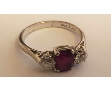 An 18ct white gold and platinum ladies diamond and ruby 3 stone ring. The diamonds approx 20pnts with the central ruby 75pnts