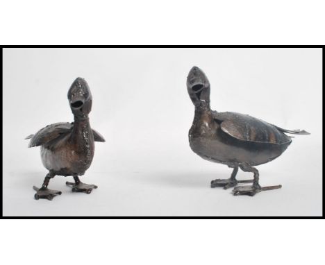 A pair of vintage 20th century patinated metal panel beaten ducks of crude form.&nbsp; Measures 15cms high.