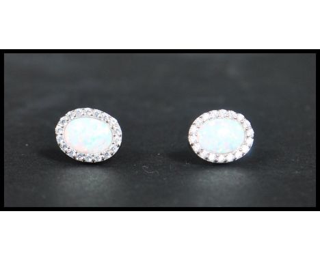 A pair of sterling silver and opal earrings with post backs complete in presentation box.