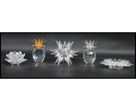 A group of Swarovski candlestick to include a sunburst example, star, lotus flower and two pineapple examples with hammered s