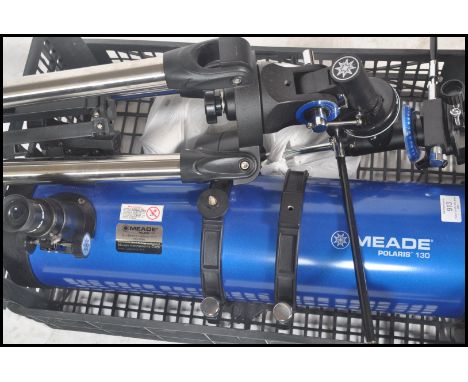 A Meade Polaris 130 astrology telescope raised on adjustable tripod base.