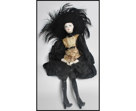 An early 20th century Art Deco French Boudoir cabaret doll. The ceramic head painted in a burlesque manner with a black and g