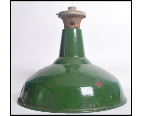 An early 20th century green and white two tone enamel painted metal factory pendant light. Space age form with bracket atop. 