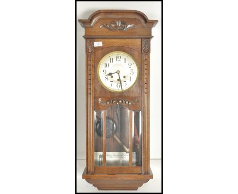 A vintage 1930s oak cased drop pendulum striking wall clock of typical form, Roman Numeral chapter ring fitted with glazed do