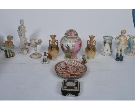 A Chinese blanc de chine figurine of a deity together with a German biscuit glaze cherub figurine candlestick by LHS Germany,