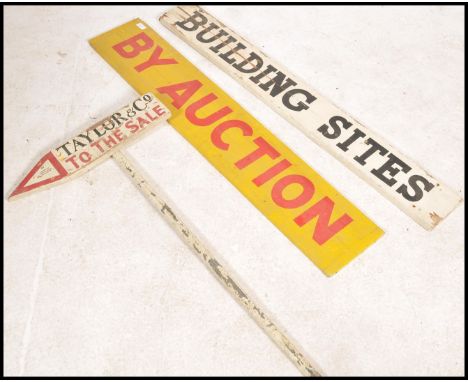 A collection of vintage wooden mid century auction advertising signs. To include a yellow and red long wooden double sided si