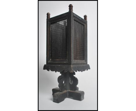 An unusual early 20th century Chinese candleholder lamp shade stand of ebonised and square form, believed to be pine wood, ra