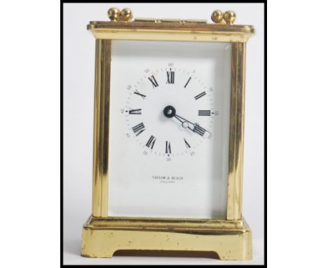 A vintage 20th century brass cased carriage clock with white dial and roman numeral chapter ring by Taylor &amp; Bligh of Lon