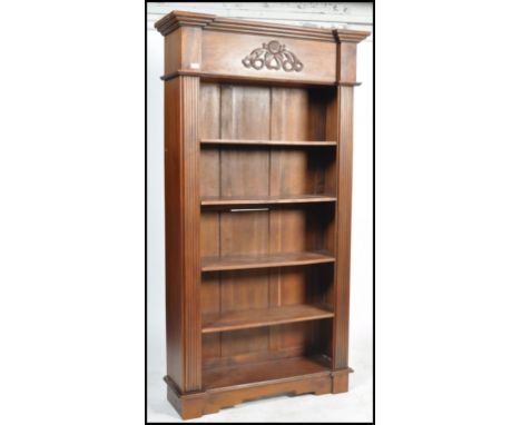A large 20th century Antique Victorian style revival tall bookcase. Raised on bracket feet with upright body of shelves havin