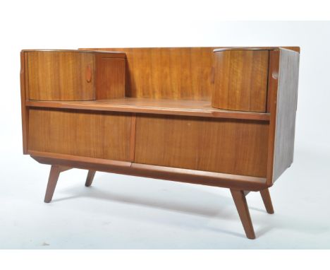 A retro 20th century teak wood side table dressing chest being raised on tapering legs with central drawers with trinket draw