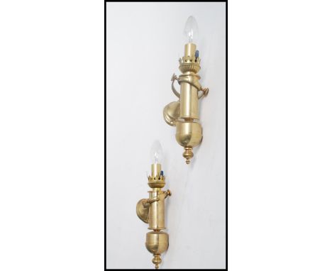 A pair of 20th century brass wall mounted architectural wall lights of conical form with inverted turned finials.&nbsp;