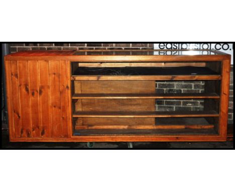 A large antique style pine shop haberdashery counter. Of heavy long form with glazed panelled display shelf front and top wit