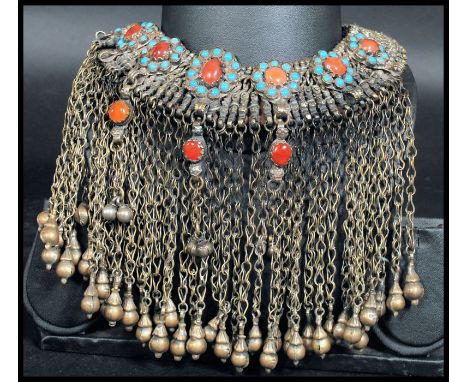 A 19th century Chinese silver white metal headdress having various bell chain drops with turquoise and carnelian flowers.