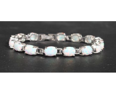 A sterling silver and opal panel bracelet having prong set opal cabochons with a hidden fold over clasp. Measures 7 inches an