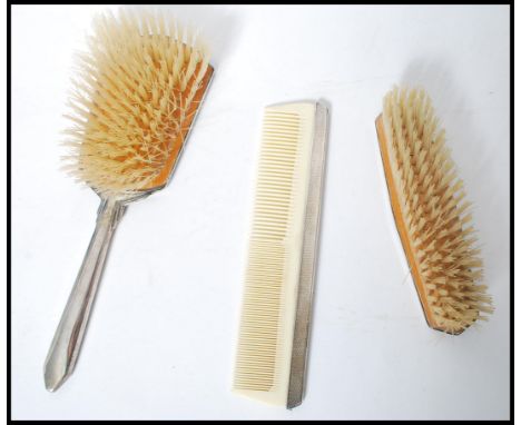 A three piece silver hallmarked art deco dressing table brush and comb set. Each piece being hallmarked for Birmingham and ha