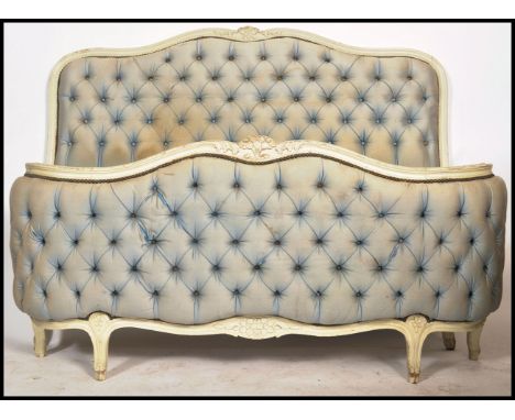 An early 20th century upcycled French bow fronted corbeille bed with a blue silk button backed upholstered head and footboard