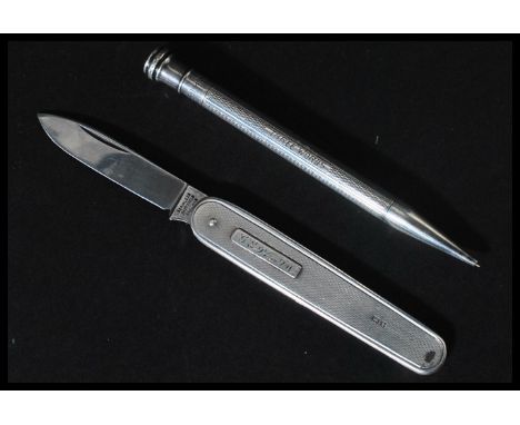 A silver propelling pencil along with a silver hallmarked penknife having engine turned decoration with London hallmarks.