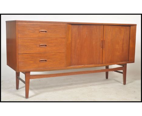 A vintage retro 20th century 1970's teak three drawer sideboard having sliding doors raised on tapered legs. Makers Austinsui