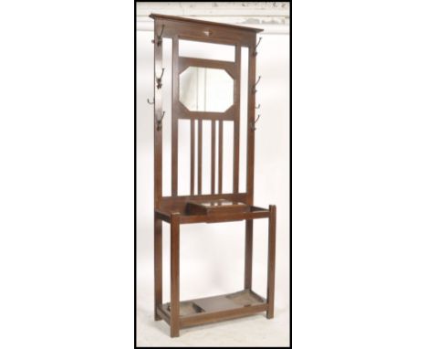 An Edwardian mahogany hallstand of upright form having mirror glass to the top centre flanked by coat hooks with stick stands