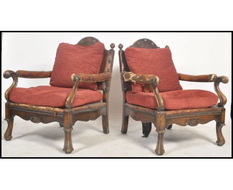 A pair of 1920's Carolean revival beech wood and leather armchairs. Raised on shaped paw feet with studded leather and horseh