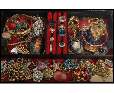 A vintage jewellery box containing brooches , rings, decanter label , Russian brooch etc. Please see images.