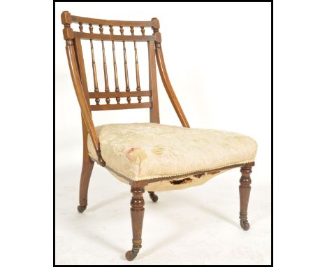 A Victorian Arts &amp; Crafts mahogany bedroom chair - open armchair. Raised on turned and tapering legs with ceramic castors