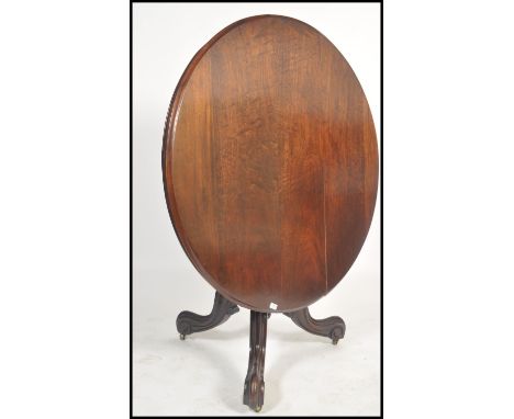 A 19th century Victorian mahogany tilt top dining table. Raised on a tripod base with shaped column support having a circular