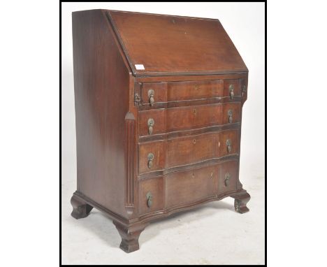 An early 20th century Shoolbred of London bombe serpentine fronted bureau of small proportions. Raised on bracket feet with&n