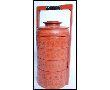 A vintage 20th century Oriental Chinese stacking lunchbox having a painted red body with painted scenes. 42cms high.