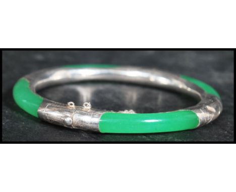 A sterling silver 925 stamped and jade bangle having a hidden clasp with safety chain.