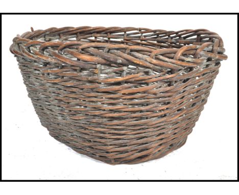 A large vintage 20th century wicker log basket of usual woven form having a stained finish. Measures 44cm x 92cm x 74cm.
