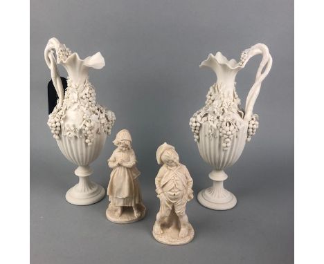 PAIR OF 20TH CENTURY CERAMIC EWERS, with grape decoration, 26cm high, along with a white painted jug, two composite figures a