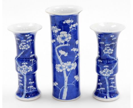 A Chinese porcelain prunus vase trio, comprising two gu shaped vases and a cylinder vase of trumpet form, decorated with prun