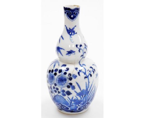 A Chinese porcelain blue and white double gourd vase, decorated with a butterfly above flowers, four character Kangxi mark, 1