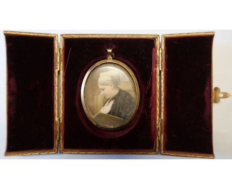 A 19th century oval portrait miniature, painted on ivory of a woman reading, maximum diameter 2.75ins, in a leather covered t