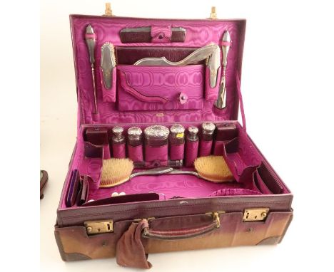 A leather covered travelling case, with cloth outer cover, the interior fitted with silver mounted glass bottles and jars, br