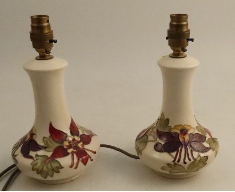 A pair of Moorcroft pottery lamp bases, decorated in the Columbine pattern, height 10ins
