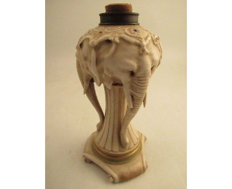 A continental porcelain oil lamp base, modelled as three elephant heads, af, height 10ins - two of the tusks are chipped and 